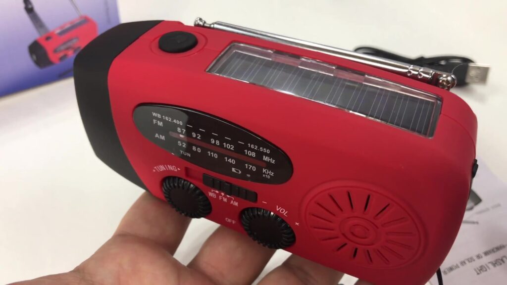 Noodradio met zonnepaneel en handslinger in de hand