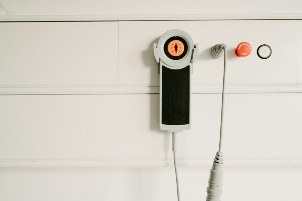 Oudere vrouw met een alarmknop aan een koord om haar hals
