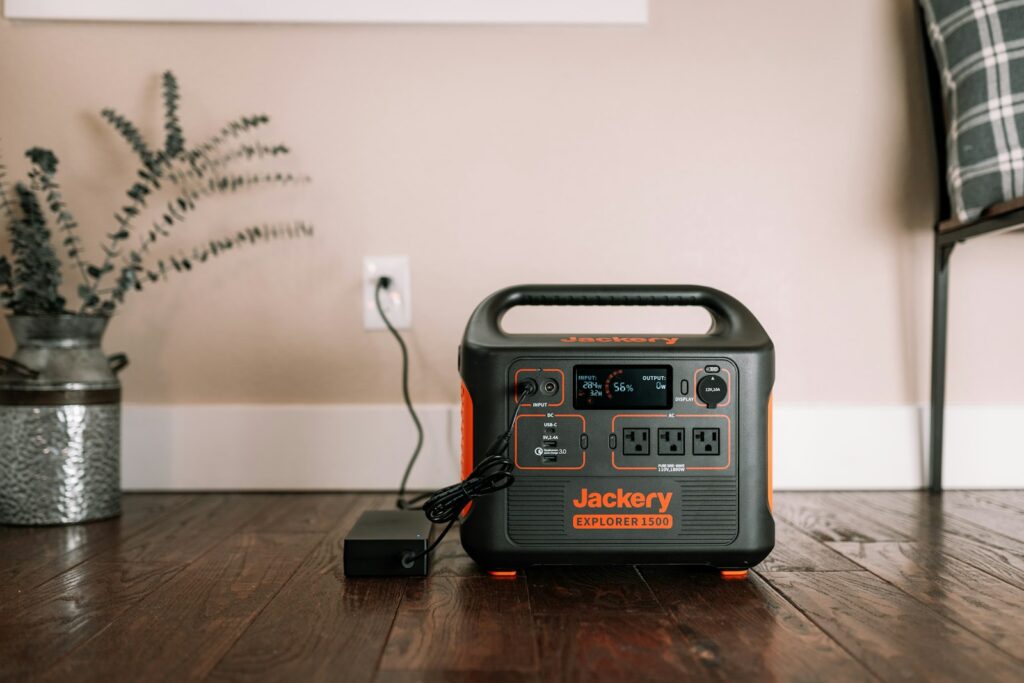 Klein draagbaar powerstation met een opgeladen telefoon en een lamp op tafel