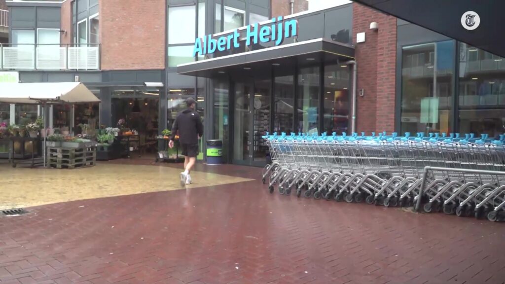 Ingang van een Albert Heijn-filiaal met winkelwagens ervoor
