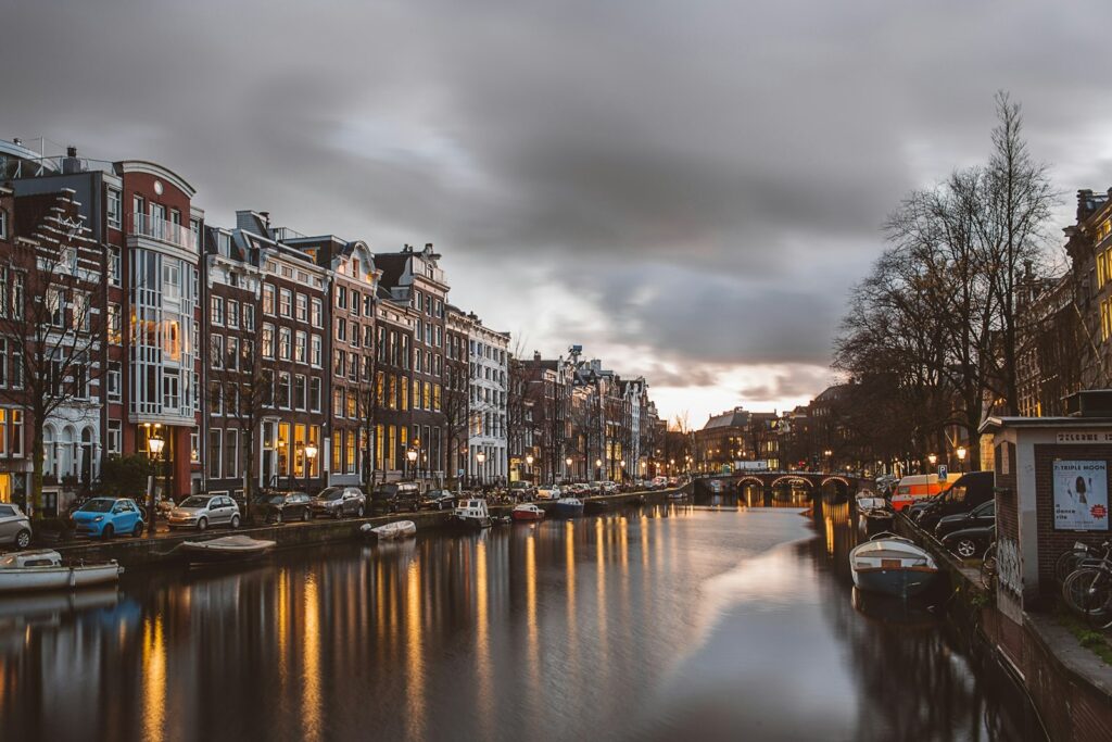 Donkere stadsstraat met grachtenpanden bij avond