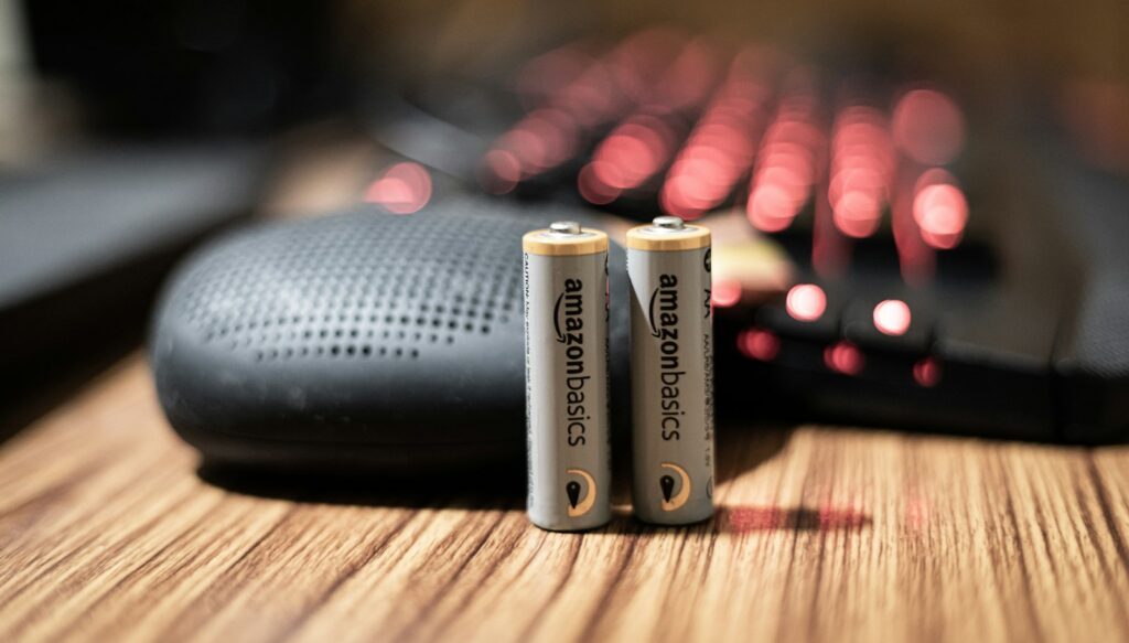 Verschillende AA- en AAA-batterijen naast een zaklamp en een noodradio