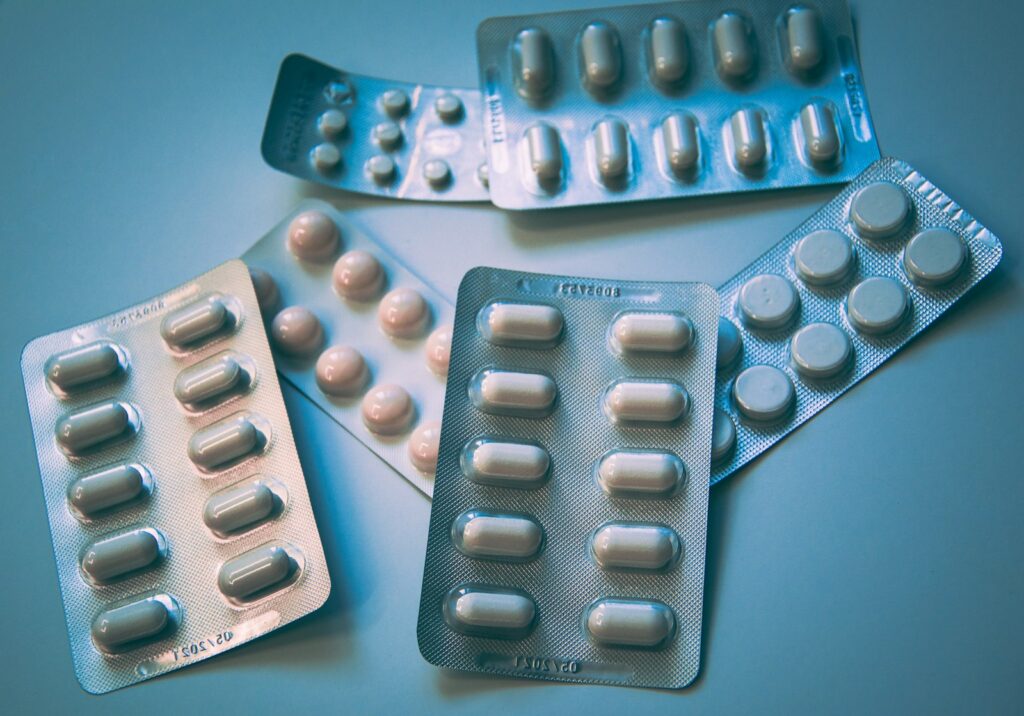 Doosje tabletten naast een glas water op een keukentafel