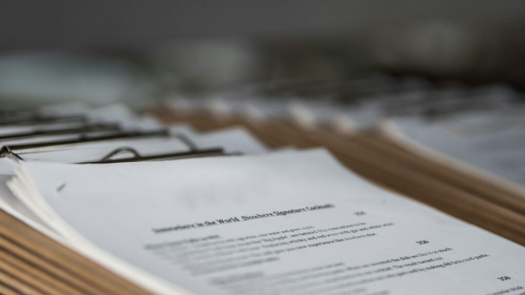 Map met papieren documenten en een geprinte lijst op een bureau