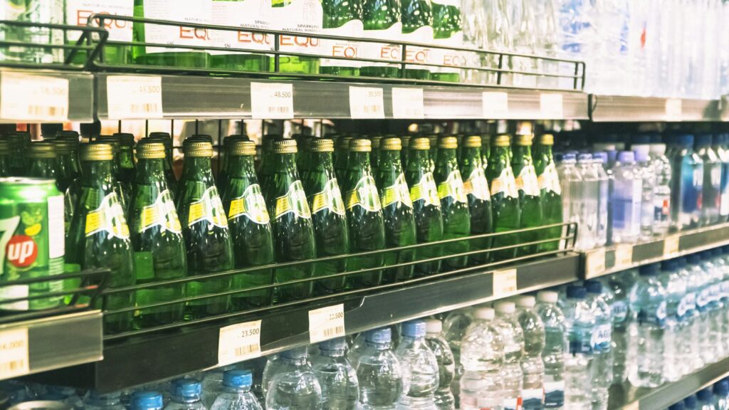 Flessen en een jerrycan met drinkwater op een plank in een berging