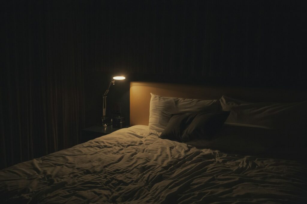 Hoofdlamp en telefoon met powerbank op een nachtkastje in het donker