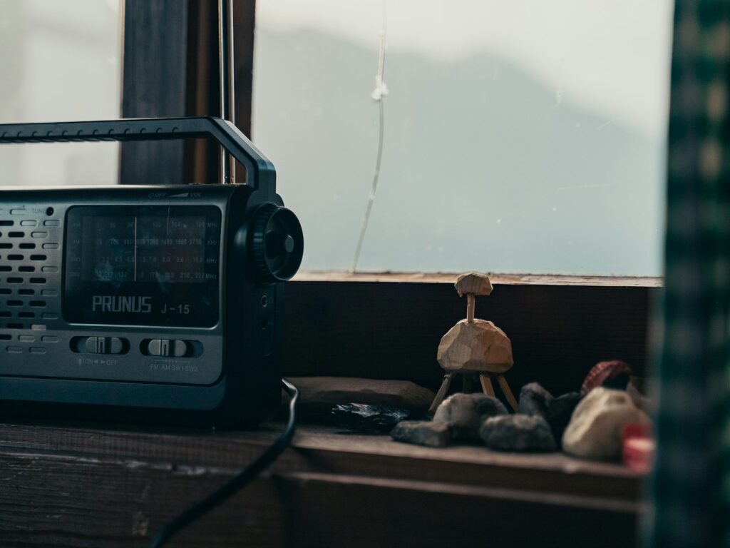 Draagbare noodradio met uitgetrokken antenne op een vensterbank