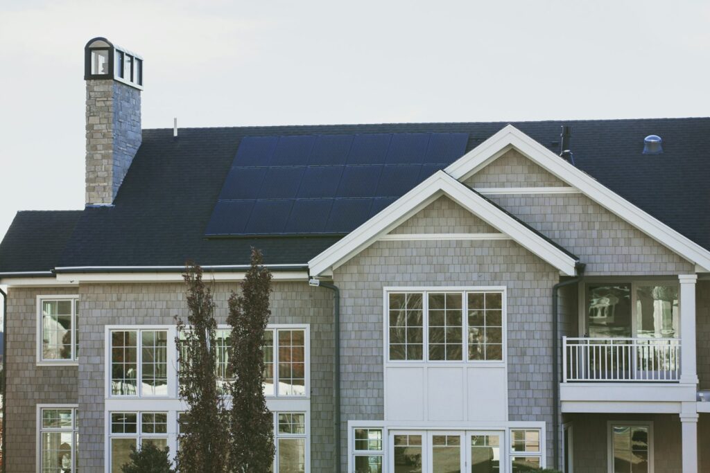 Zonnepanelen op het dak van een rijtjeshuis onder een bewolkte lucht
