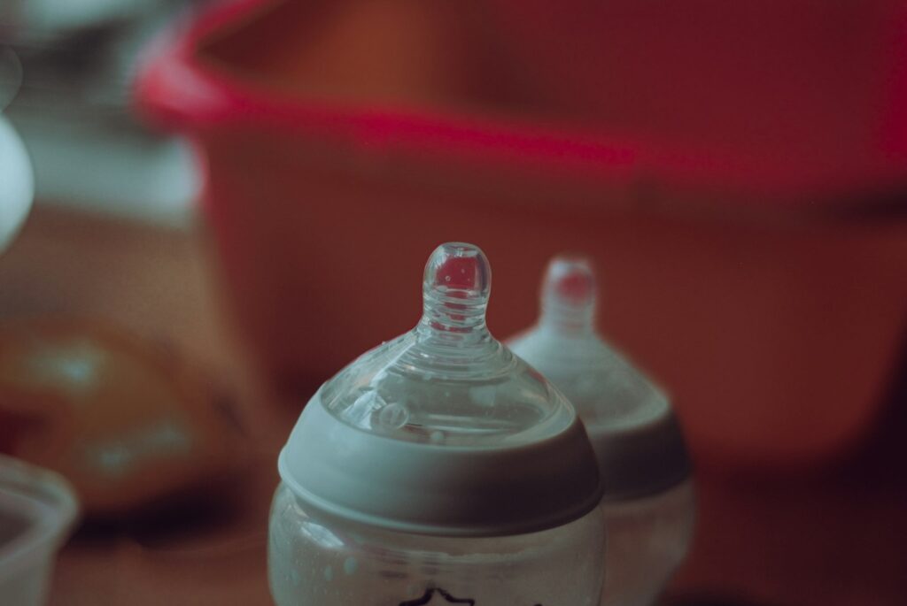 Babyfles met melk naast een thermosfles op een keukentafel