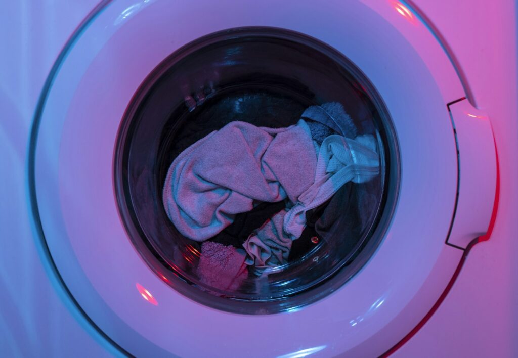 Voorlader wasmachine met gesloten deur en wasgoed in de trommel