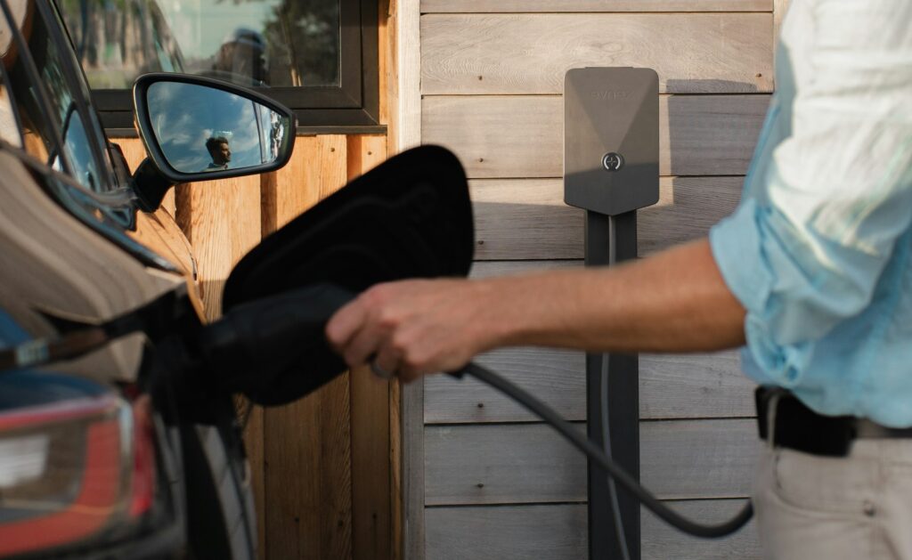 Elektrische auto aan de laadkabel op een oprit bij een woning