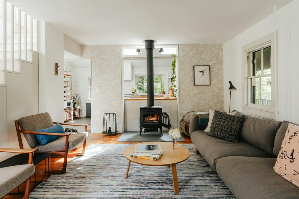 Houtkachel met vuur in een woonkamer met een wollen deken op de bank