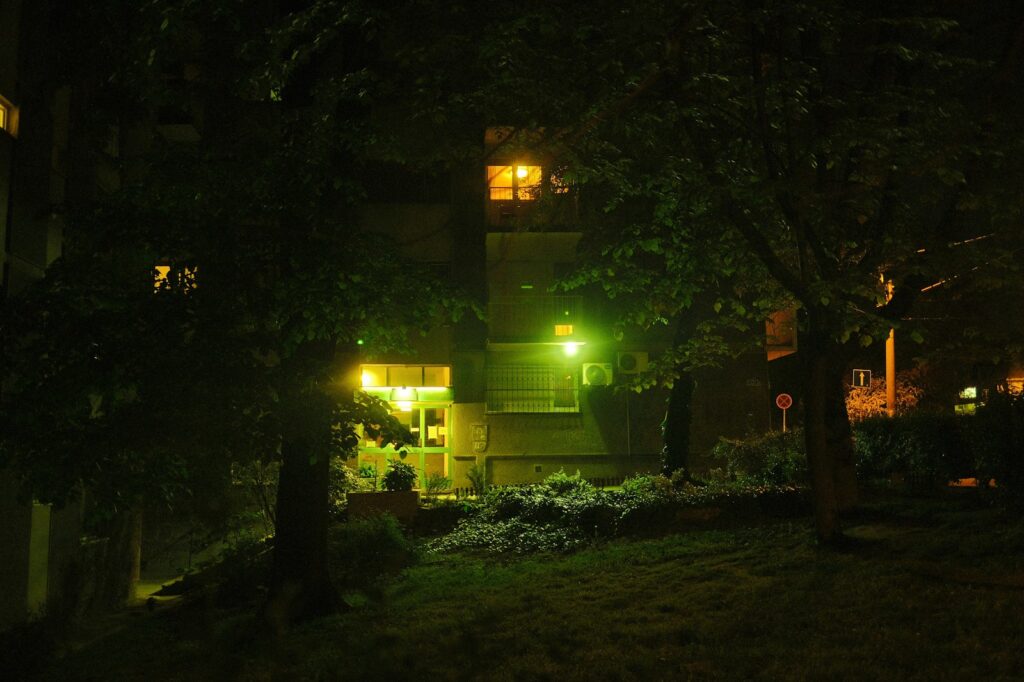 Woonstraat in de avond met donkere ramen en uitgevallen straatverlichting
