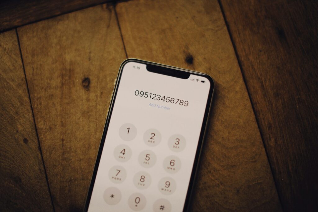 Mobiele telefoon naast een briefje met belangrijke telefoonnummers op een keukentafel