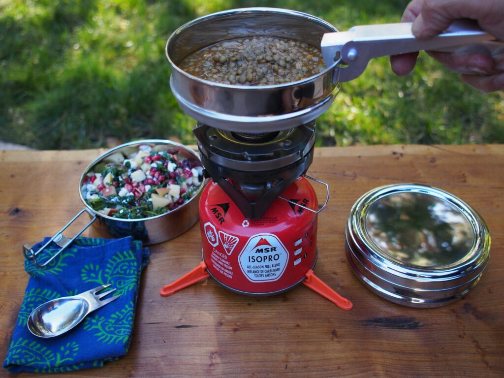 Pan met kokend water op een campingbrander buiten