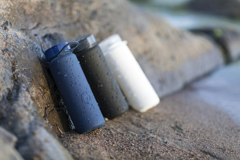 Draagbaar waterfilter in een rugzak naast een fles water